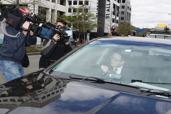 A man entering an AFP-marked vehicle after a raid in October at the Department of Home Affairs Canberra headquarters.