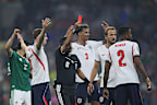 Referee Alireza Faghani shows a red card to Jarell Quansah.