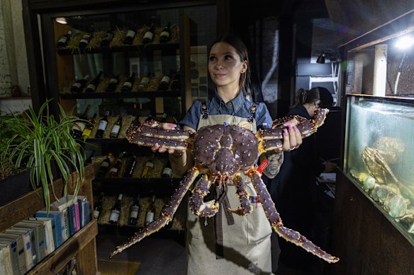 A waitress displays Vladivostok king crab to Chinese customers.