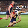 Brad Close of the Cats kicks whilst being tackled by Jack Viney of the Demons.