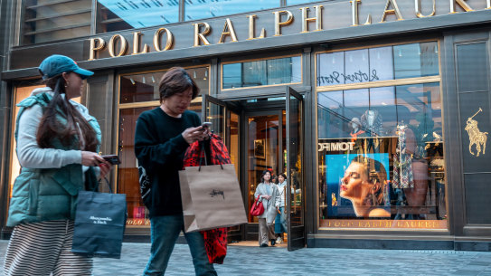 Shoppers walk pass the World of Ralph Lauren in Taiku Li Sanlitun, a popular shopping and dining area in Beijing.