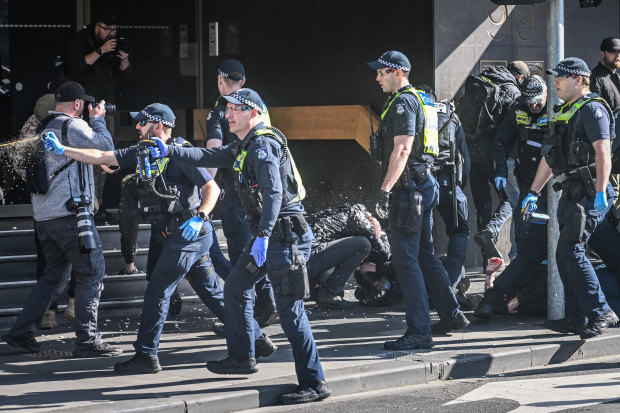 Police officers use capsicum spray during a demonstration in Melbourne’s CBD last Saturday.