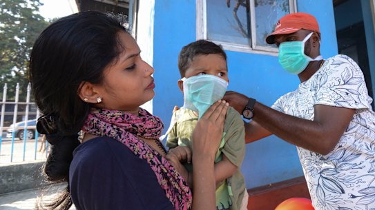 A child's mask is adjusted at a hospital in Kerala, where India's first case of coronavirus has been identified.