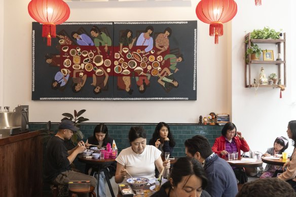 The dining space is simply but brightly furnished with red lanterns and tiles. 