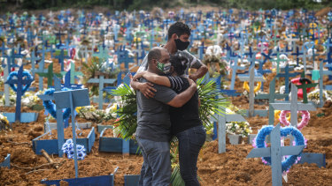 A family mourns their relative at a cemetery in Manaus, Brazil, where hundreds of COVID-19 victims have been buried.