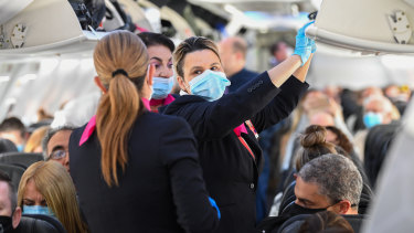 Passengers and crew onboard a Qantas Boeing 737-800, flight number QF735 from Sydney to Adelaide at Sydney Airport.