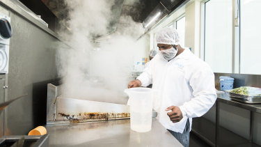 Chef Balraj Kumar preapres hot meals in the kitchen of airline caterer dnata's facility in Canberra.