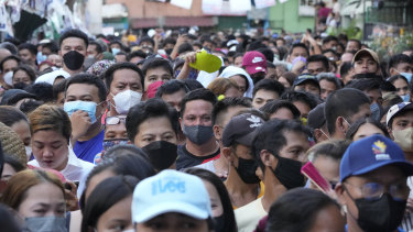Manila'nın Tondo ilçesinde sandık merkezi olarak kullanılan bir okulda vatandaşlar oy kullanmak için kuyrukta bekliyor.