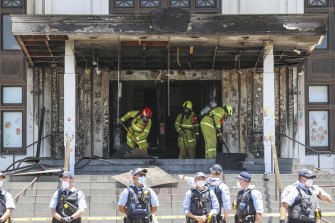 Firefighters  at the fire-damaged front entrance of Old Parliament House.