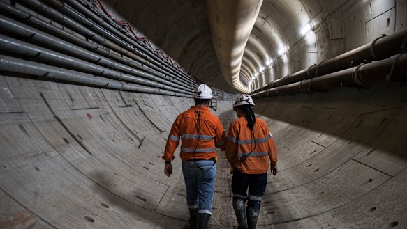 Workers walk down a section of the metro beneath Sydney Harbour.