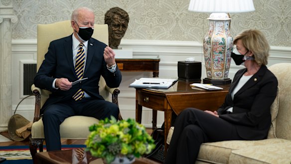 Senator Tammy Baldwin listens as President Joe Biden holds up a microchip during a meeting with lawmakers to discuss US supply chains.
