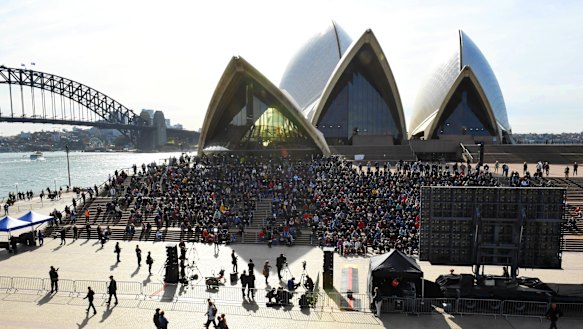 Mourners sitting on the Opera House steps for Bob Hawke's memorial.