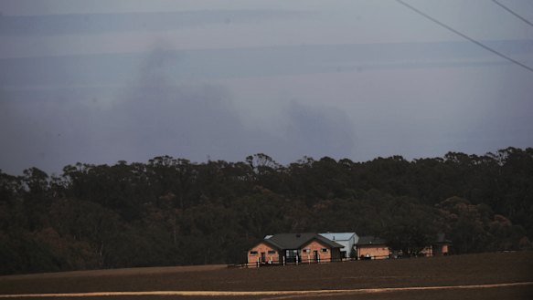 A weak plume rises from the Wombeyan  Caves area as hot north-westerly winds flare up the southern flank of the Green Wattle Creek fire.