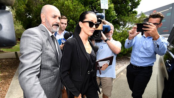 Basic (centre) is escorted to a limousine following her sentencing for drink driving.