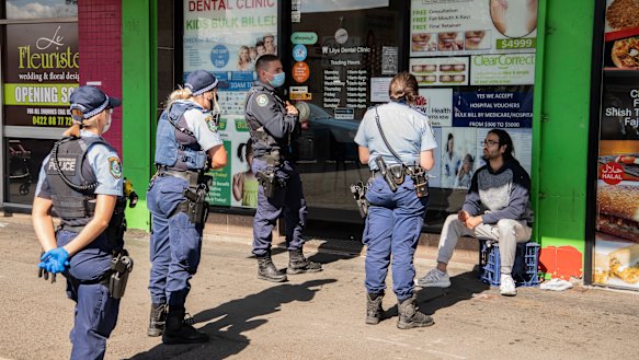 Out in force: Police in western Sydney speaking to a man not wearing a mask.