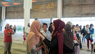 Zainab Badra helps Barbara Hughes of Williamstown put on a hijab at the Newport mosque.