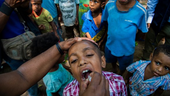 A child in Papua New Guinea receives a polio vaccine. The coronavirus outbreak threatens to reverse decades of global progress in alleviating poverty.