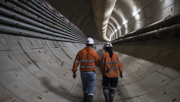 Workers walk down a section of the metro beneath Sydney Harbour.