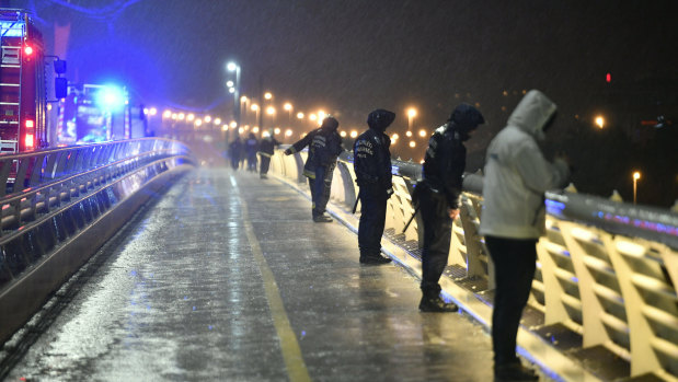 Rescuers and police officers inspect the River Danube from a landing dock after a tourist boat crashed with another ship.