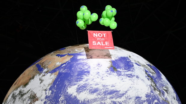 Greenpeace activists float a sign over a globe at the COP26 summit venue. 