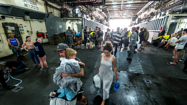 People boarding HMAS Choules after being ferried from Mallacoota.
