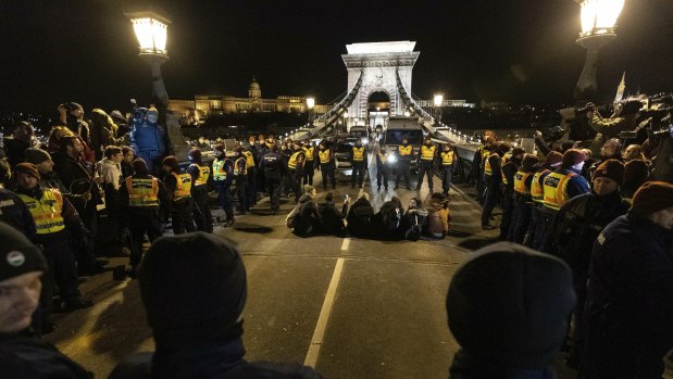 Police confront the crowd on the Chain Bridge during a protest against  labour laws in Budapest, Hungary, on Saturday.