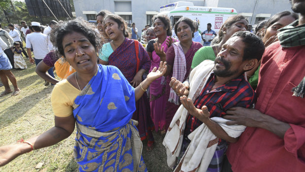 Indians mourn the death of relatives in a case of food poisoning at Hanur, near Sulawadi village in Chamarajnagar district of Karnataka state, India, on Saturday.