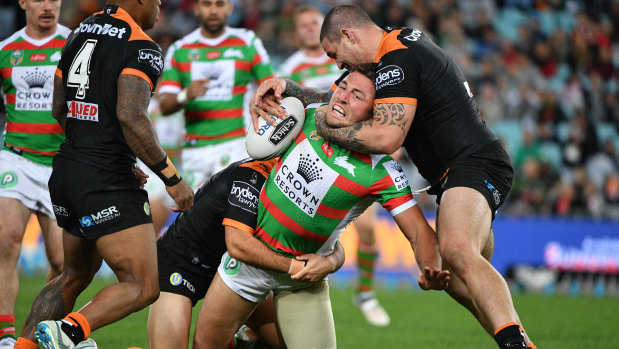Throttled: Sam Burgess is taken around the neck by the Tigers defence.