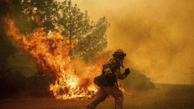 Some jobs present significantly higher risks to life. A firefighter runs while trying to save a home as a wildfire tears through Lakeport, California.