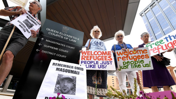 Placards are held at a vigil outside the Brisbane Magistrates Court on Monday.