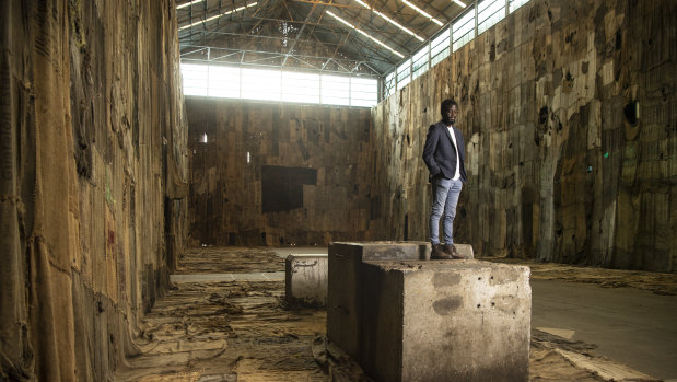 Portrait of Ibrahim Mahama with his art work ’No Friend but the Mountains', 2012-2020 at Cockatoo Island in Sydney which is part of the 22nd Biennale of Sydney.
