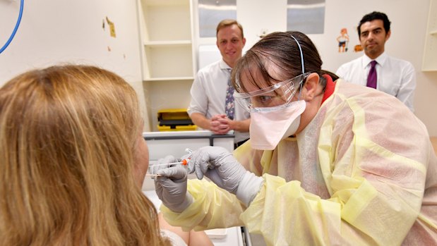 Clinical nurse consultant Janice Geary demonstrates the testing procedure for Queensland Health Minister Steven Miles at the Prince Charles Hospital.