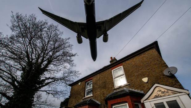 A plane comes in to land at Heathrow airport over nearby houses in London.
