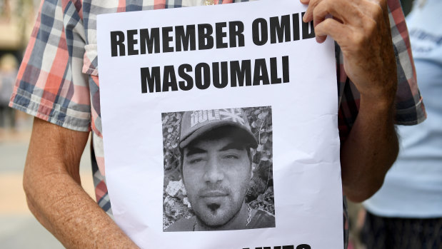 A photograph of Omid Masoumali is held outside the Brisbane Magistrates Court in Brisbane.