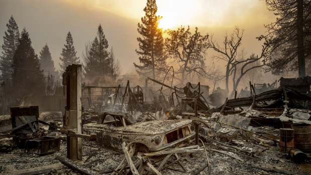 A vintage car rests among debris as the Camp Fire tears through Paradise, California.