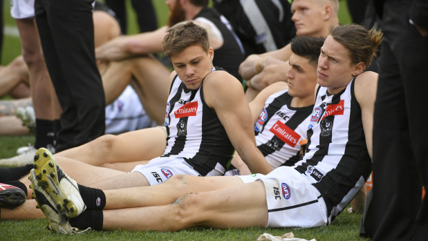 So close: Collingwood players sit through the grand final presentations.
