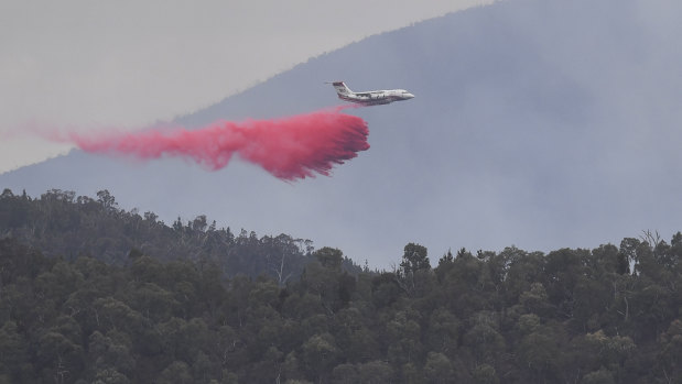 A water bombing airplane is seen dropping fire retardant at the Pierces Creek fire near Canberra on Friday.