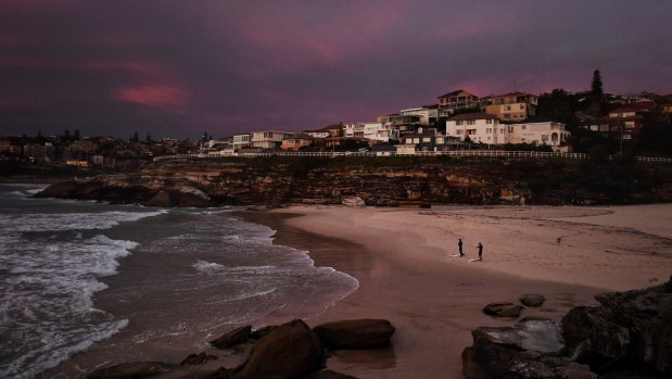 Surfers and swimmers have been climbing and squeezing around barriers to use Tamarama Beach at dawn.