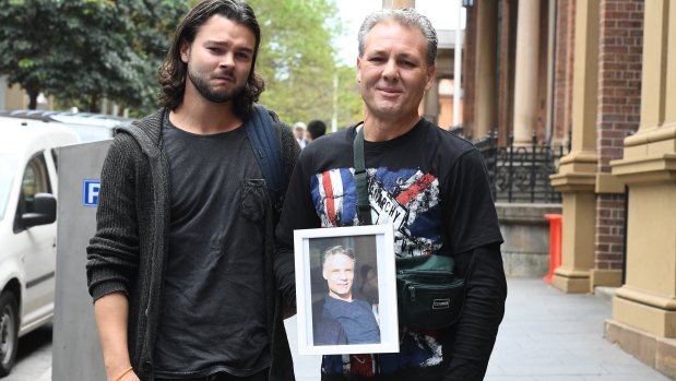 Dustan Mileham and Danie Sims with portraits of their older brother outside court on Friday. 