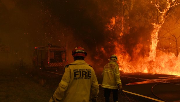 Fire and Rescue NSW escape flames as the Gospers Mountain fire crosses the Bells Line of Rd at Berambing.