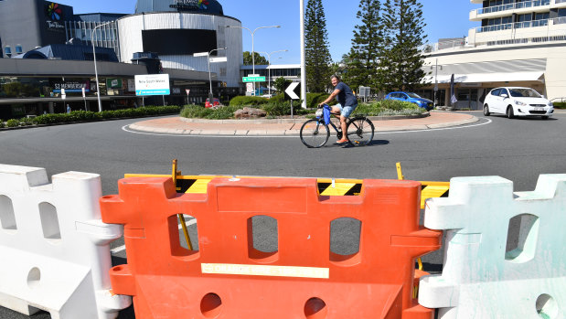 A cyclist is seen riding past a barrier across the Queensland and New South Wales border in Coolangatta during the lockdown.