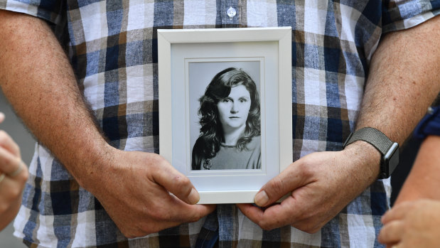 A family member is seen holding a photograph of Patricia Riggs outside the Brisbane Supreme Court in February.