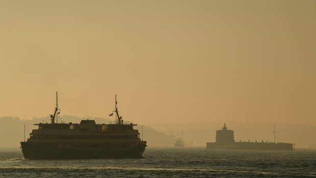 A commuter ferry moves through the thick smoke blanketing Sydney Harbour on Friday morning. 