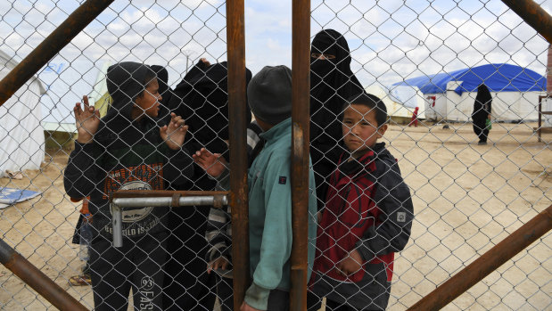 Foreign IS wives and children at the fence line of the foreign section of Al Hawl camp in Syria.