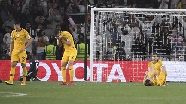 Down and out: The Socceroos come to terms with defeat at the Asian Cup.