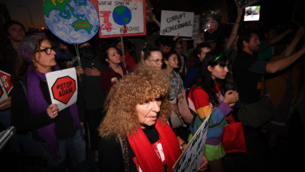 Protesters opposing to the construction of the Adani coal mine hold signs during a rally in Brisbane.