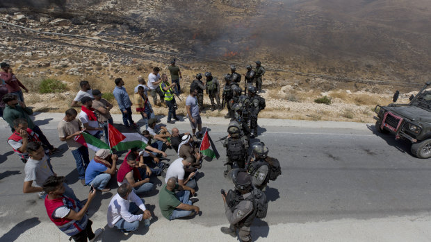 Israeli border police block the road and disperse Palestinian, Israeli and foreign activists during a rally on Friday against a newly established settlement near the West Bank village of Kufr Malik, east of Ramallah.
