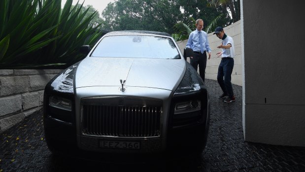Michael Pallier talks to a Chinese client next to his Rolls-Royce.
