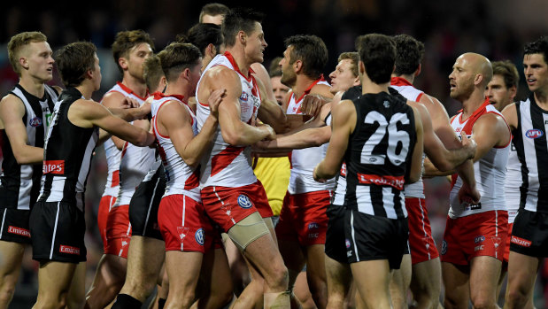 High stakes: Swans and Magpies players scuffle as tensions heat up.