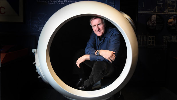 James Cameron poses for a photo with a scale model of the Deepsea Challenger cockpit at the media preview of the Challenging the Deep Exhibition at the Australian National Maritime Museum in Sydney.